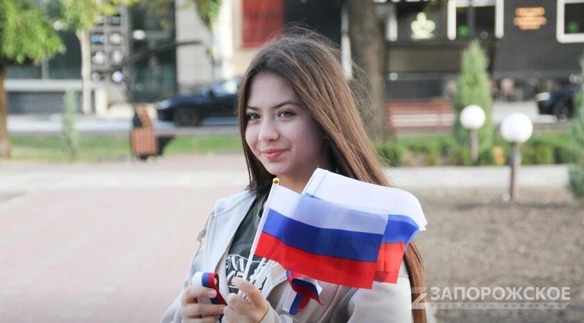 Волонтеры Победы в Мелитополе раздали более 500 лент-триколоров и флагов в честь Дня воссоединения